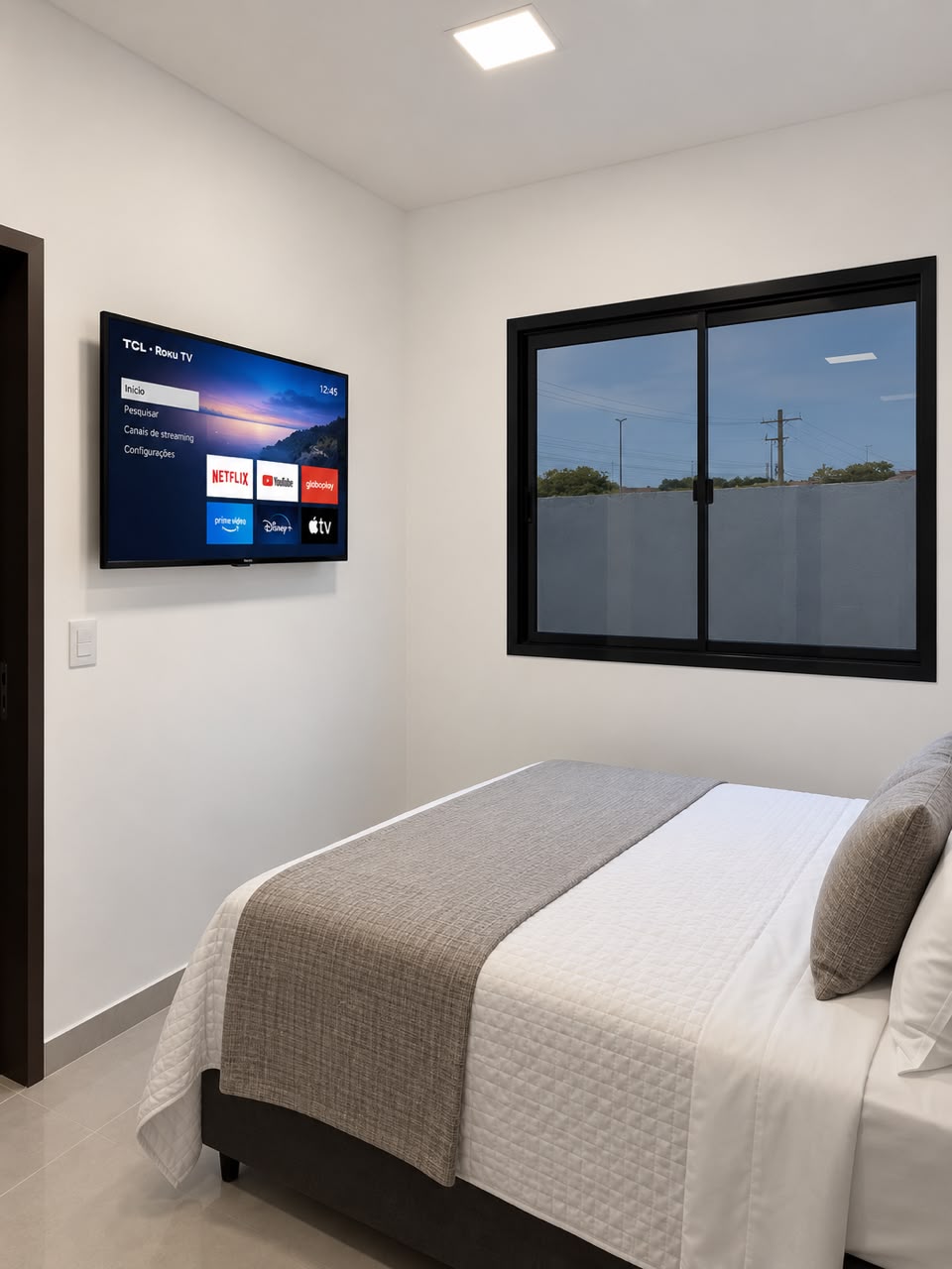 Quarto de casal do Teles Plaza com cama de casal, televisão e janela