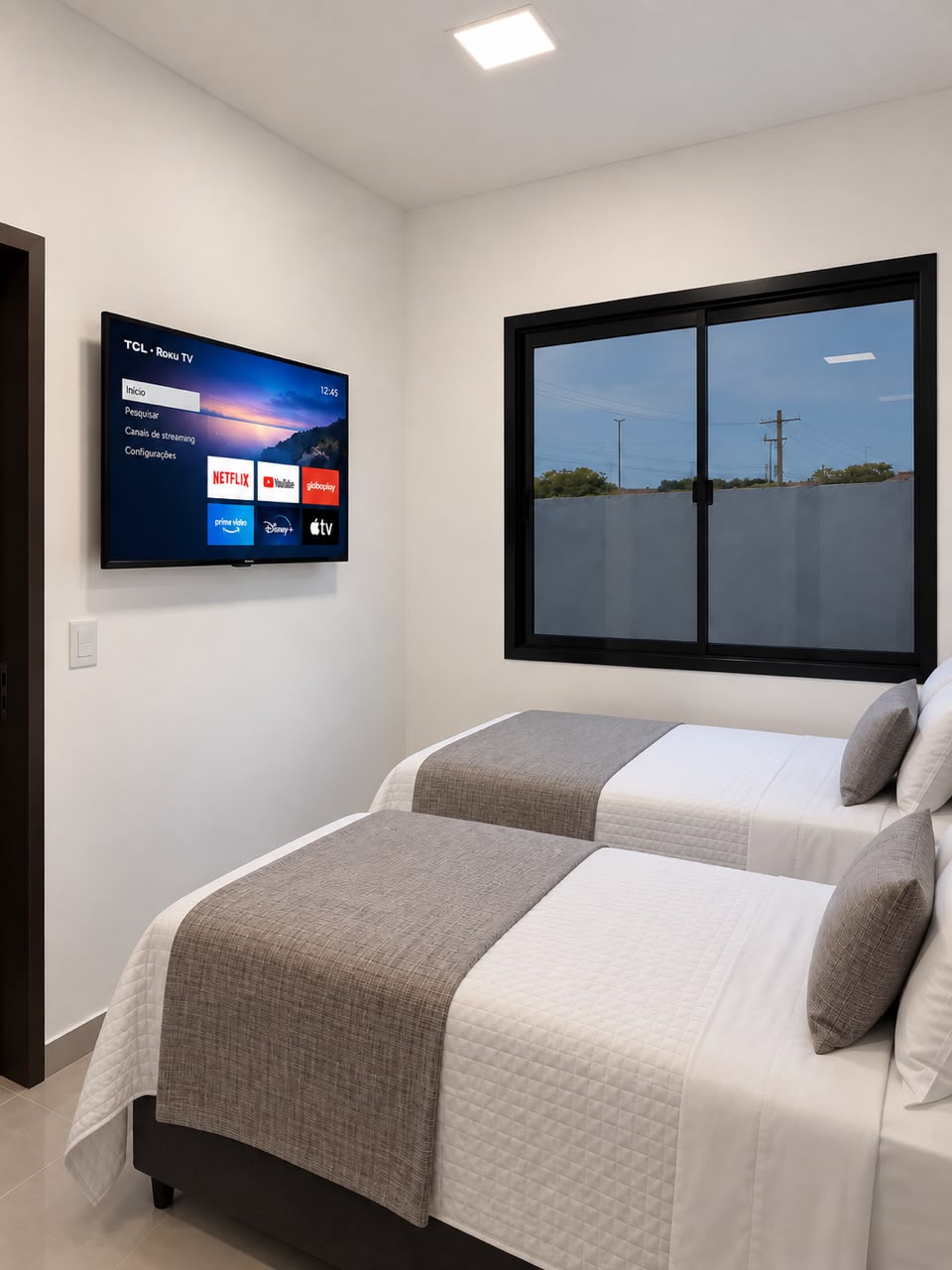 Quarto duplo do Teles Plaza com duas camas individuais e televisão